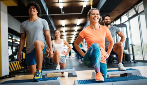 Group of young people doing exercises together in gym